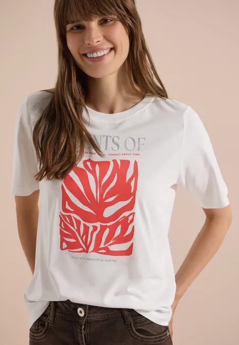Frau trägt weißes T-Shirt mit rotem, abstraktem Blattmuster und grauem Schriftzug.