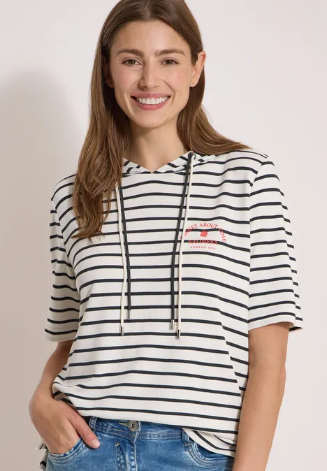 Hoodie met korte mouwen en strepen vanilla white Vrouw in een wit, maritiem gestreept korte mouw hoodie en een blauwe spijkerbroek.
