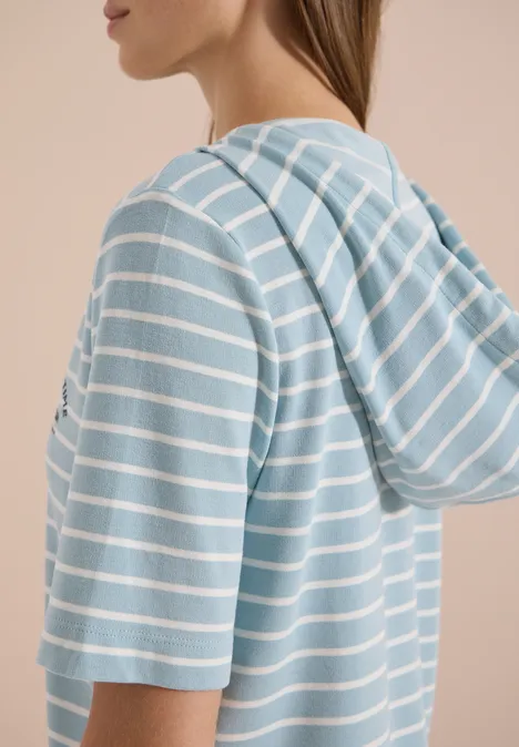 Hoodie met korte mouwen en strepen crystal mint Zijaanzicht van een persoon in een lichtblauw-wit gestreept T-shirt met korte mouwen en capuchon.