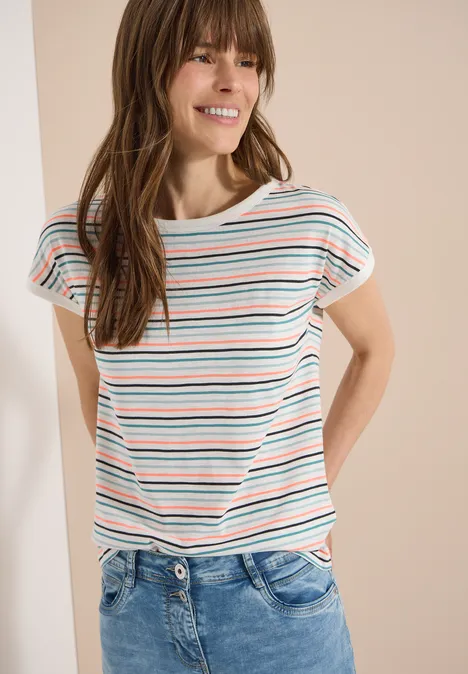 T-Shirt mit Boat Neck und Turn-Up-Detail vanilla white Frau in gestreiftem T-Shirt und blauer Jeans steht lässig mit den Händen am Rücken.