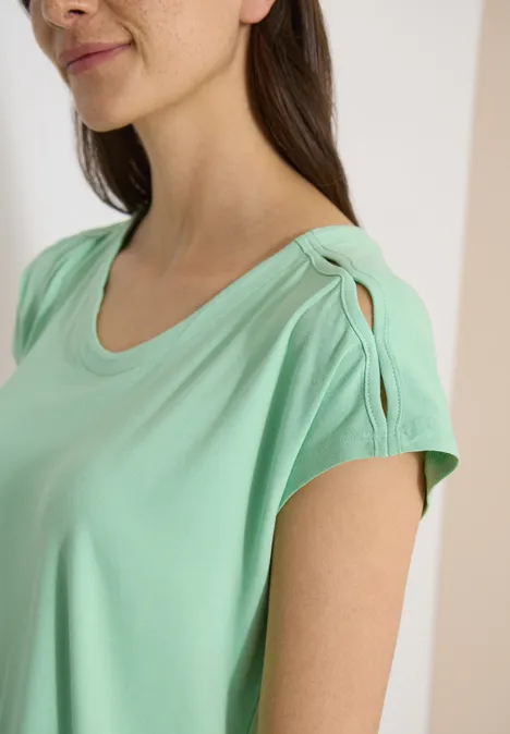 Detailfoto van een persoon in mintgroen T-shirt met gedraaide schouderband.