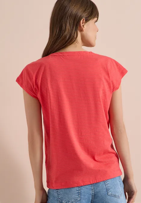 Femme de dos portant un t-shirt rouge à rayures et un jean.