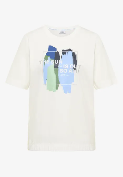T-shirt blanc avec coups de pinceau bleu et vert et inscription 'THE SUN IS OUT SO AM I'.