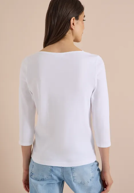 T-shirt basique à col bateau White Frau von hinten in weißem Shirt mit 3/4-Ärmeln und hellblauen Jeans.