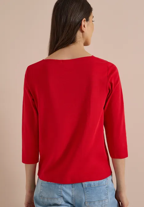 Basic shirt met boothals flame red Frau von hinten in rotem Dreiviertelarm-Shirt und blauer Jeans