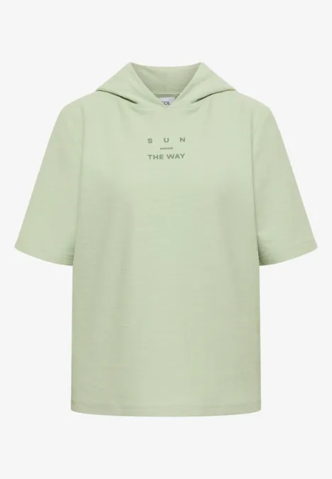 Kurzarm Shirt mit Kapuze und Wording raw matcha lime Hellgrünes kurzes Kapuzen-T-Shirt mit minimalistischem Schriftzug auf der Brust.