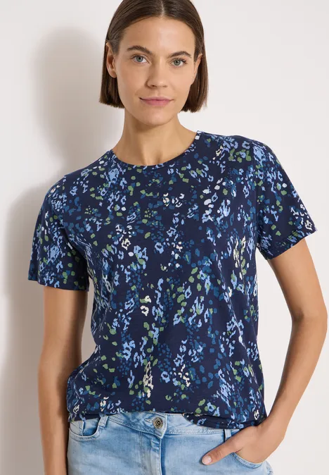 T-Shirt mit Rundhals und Print urban dark blue Frau trägt dunkelblaues, kurzärmeliges Shirt mit Blumenmuster und helle Jeans vor weißem Hintergrund