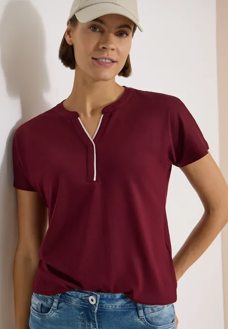 T-Shirt mit Split Neck in Unifarbe red wine Person trägt bordeauxrotes T-Shirt mit Reißverschlussschlitz am Ausschnitt und Jeans