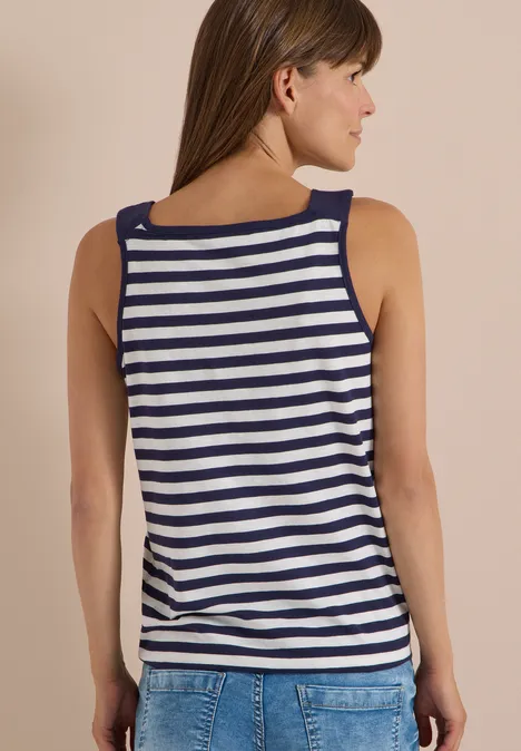 Rückansicht einer Frau in blau-weiß gestreiftem Tanktop und Jeans.