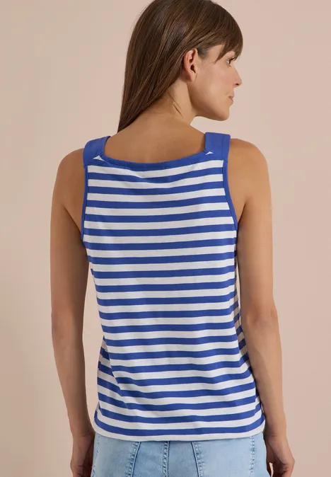 Femme vue de dos portant un débardeur à rayures bleu et blanc sur fond beige.