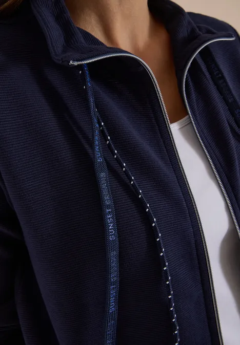 Langarm Jacke mit Ottoman Struktur urban dark blue Nahaufnahme einer Person in dunkelblauer Zip-Jacke über weißem Top.