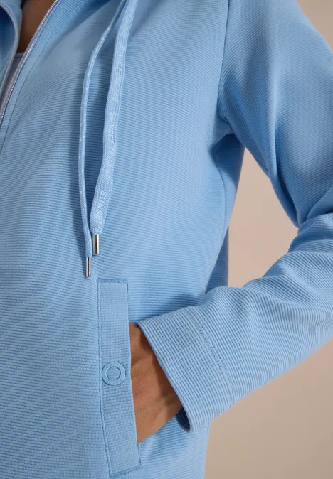 Jas met lange mouwen en ottomanstructuur easy blue Hand in de zijzak van een lichtblauw capuchonvest met rits en trekkoorden.