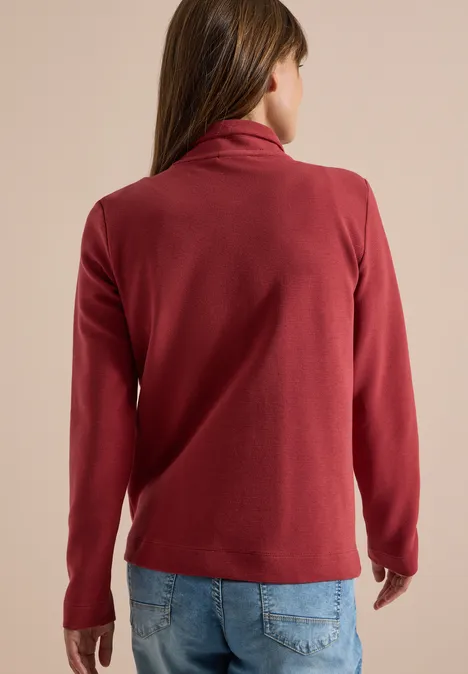Langarm Jacke mit Ottoman Struktur russet red Frau von hinten in weinrotem Fleece und heller Jeans vor beigem Hintergrund.