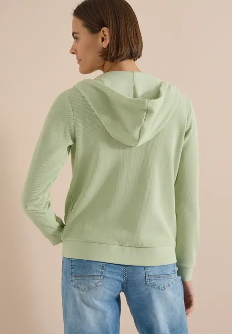 Langarm Jacke mit Kapuze und Struktur raw matcha lime Eine Person trägt einen hellgrünen Kapuzenpullover, von hinten fotografiert.