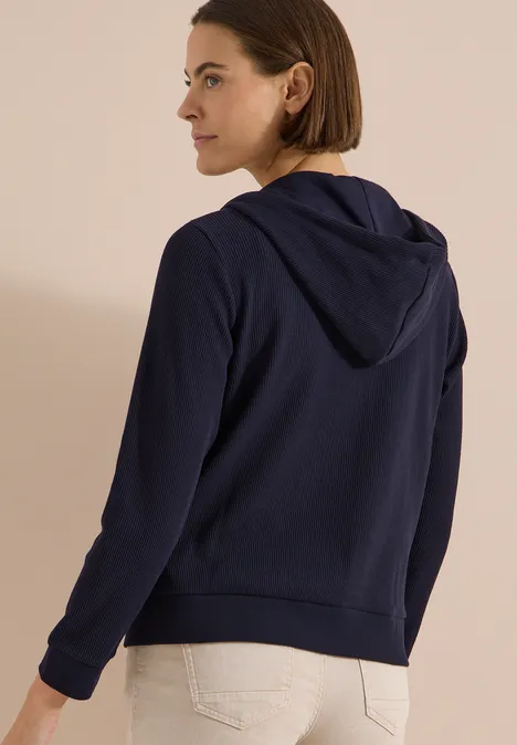 Langarm Jacke mit Kapuze und Struktur urban dark blue Rückenansicht einer Frau in dunkelblauer Kapuzenjacke und heller Hose