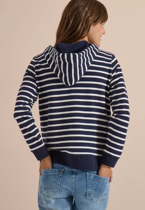 Frau von hinten in gestreiftem Kapuzenpullover und Jeans.