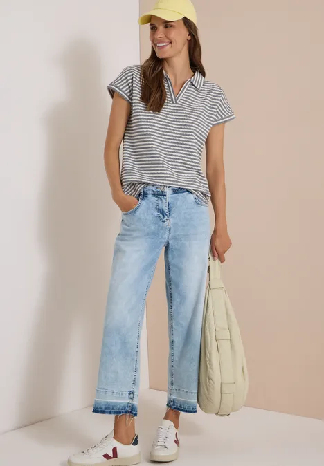 Kurzarm Poloshirt mit Streifenstruktur urban dark blue Frau im gestreiften Poloshirt, hellen Jeans und Basecap, trägt offene Sandalen und lässige Tasche.