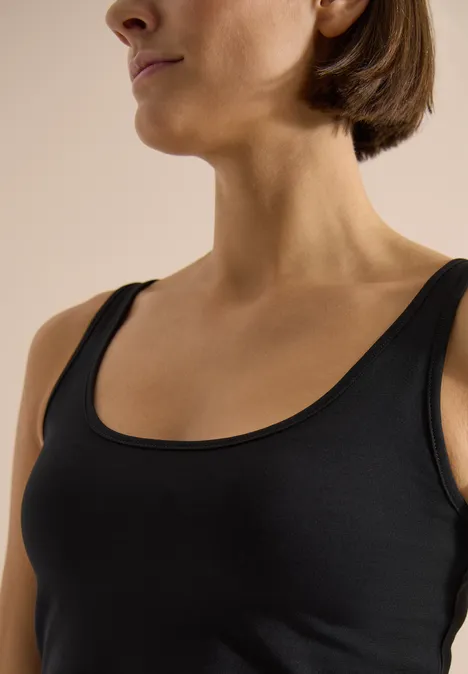 Nahaufnahme von Hals und Oberkörper in schwarzem Tanktop.