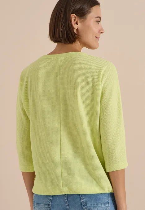 3/4-Arm Shirt mit Waffelstruktur citrin green Rückansicht einer Frau in hellem, limonengrünen Oberteil mit 3/4-Ärmeln und mittiger Naht.