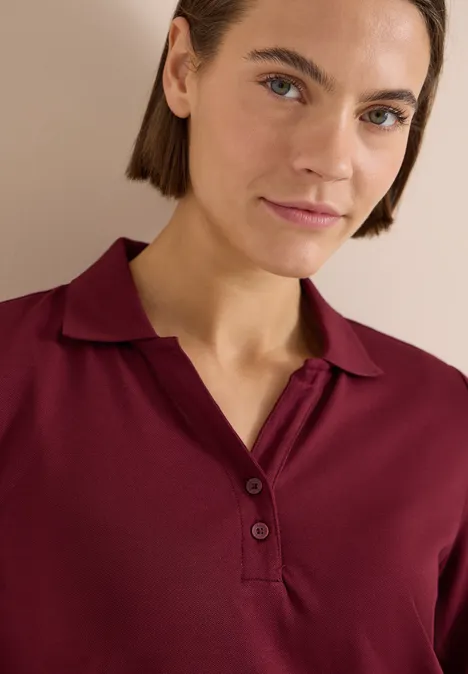 3/4-Arm Poloshirt mit Knopfdetail red wine Oberkörper einer Person in burgunderrotem Poloshirt mit offenem Kragen, Gesicht unscharf.