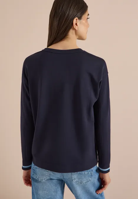 T-shirt à manches longues, col rond et rayures urban dark blue Rückenansicht einer Frau mit dunkelblauem Langarmshirt und Jeans vor hellem Hintergrund.
