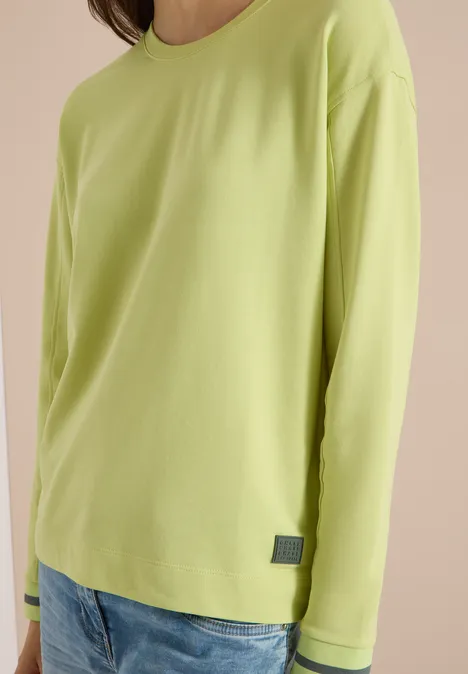 T-shirt à manches longues, col rond et rayures citrin green Eine Person trägt ein schlichtes, hellgrünes Langarmshirt aus weichem Stoff.