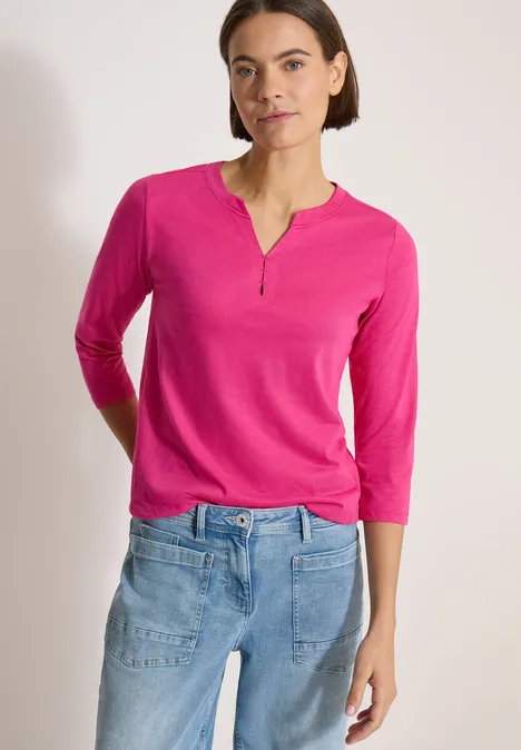3/4-Arm Shirt mit Split Neck und Elastiksaum pink flash Frau trägt pinkes 3/4-Arm-Shirt mit V-Ausschnitt und blaue Jeans.