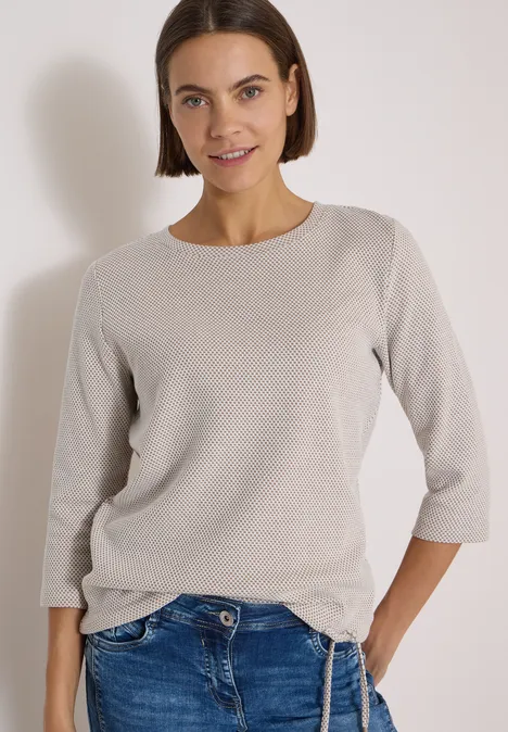 3/4-Arm Shirt mit Rundhals und Struktur natural taupe Eine junge Frau mit kurzem Bob trägt einen hellgrauen 3/4-Ärmel-Pullover und Jeans, sie lächelt.