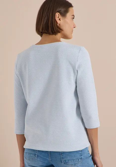 3/4-Arm Shirt mit Rundhals und Struktur easy blue Frau von hinten in hellblauem 3/4-Ärmel-Oberteil und Jeans.