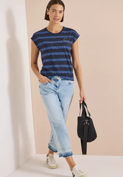 T-Shirt mit Rundhals und Leo-Streifen urban dark blue Frau trägt gestreiftes blaues T-Shirt, helle Jeans, weiße Sneaker und hält eine schwarze Tasche.