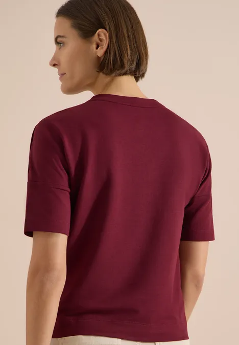 Dropped Shoulder Shirt mit Knöpfen red wine Rückansicht einer Person in einem dunkelroten kurzärmligen Oberteil.