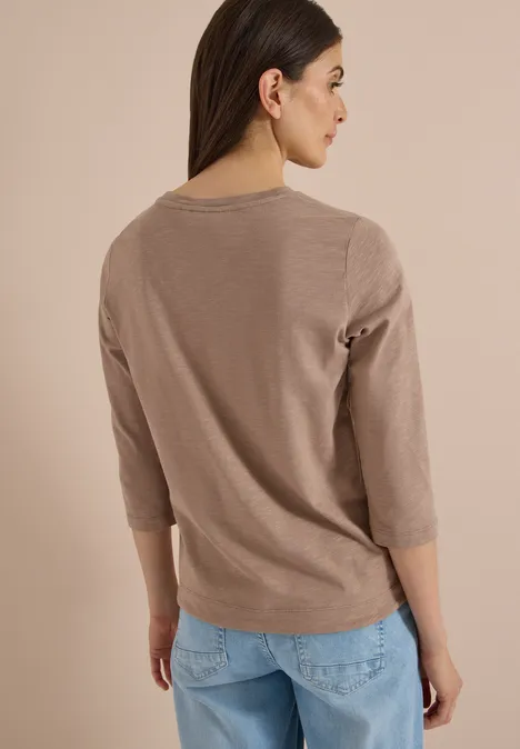 3/4-Arm Shirt mit Rundhals in Unifarbe natural taupe Frau von hinten, trägt beige 3/4-Arm-Pullover und helle Jeans.