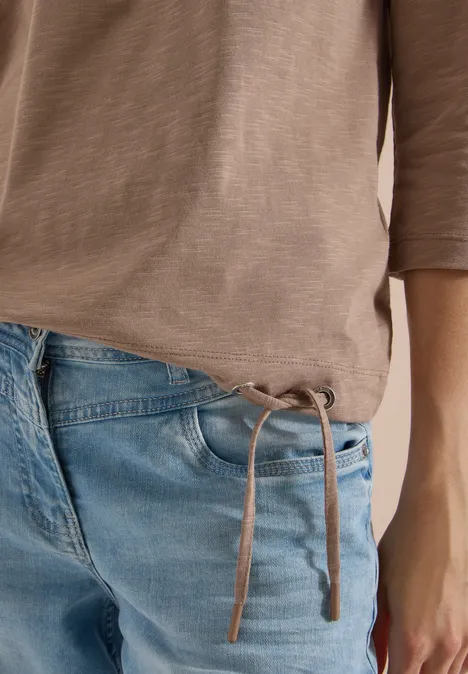 3/4-Arm Shirt mit Rundhals in Unifarbe natural taupe Nahaufnahme eines Oberkörpers mit beigem Shirt und blauen Jeans mit seitlichen Bändern am Bund.