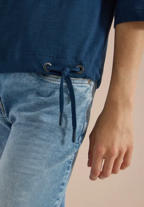 3/4-Arm Shirt mit Rundhals in Unifarbe moonlight blue Blauer Pulli mit seitlichem Tunnelzug und hellblauen Jeans; Blick auf Taille und Hand.
