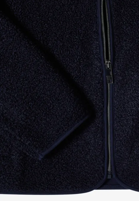 Nahaufnahme einer dunkelblauen Fleecejacke mit Reißverschluss und weichem, flauschigem Stoff.
