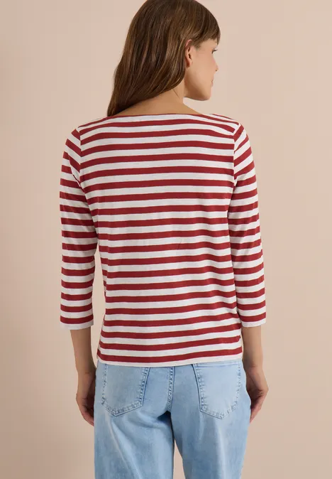 Frau von hinten in rot-weiß gestreiftem 3/4-Ärmel-Shirt und hellblauen Jeans.