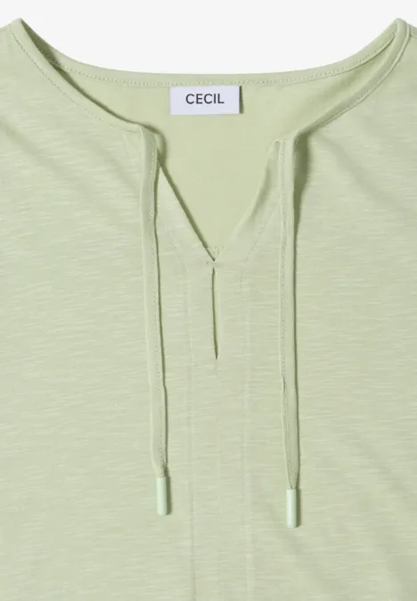 Jasnozielona koszulka z długim rękawem, dekoltem w serek z troczkami, metka 'CECIL'.