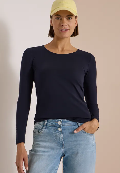 Basic Shirt mit Rundhals im 2er-Pack urban dark blue/white Frau mit gelber Cap, dunkelblauem Langarmshirt und hellen Jeans.