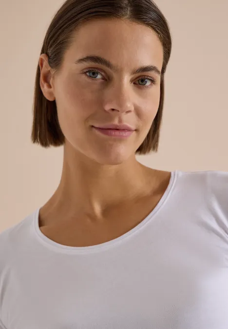 Basic Shirt mit Rundhals im 2er-Pack urban dark blue/white Porträt einer jungen Frau mit kurzem dunklem Haar und weißem Oberteil vor neutralem Hintergrund.