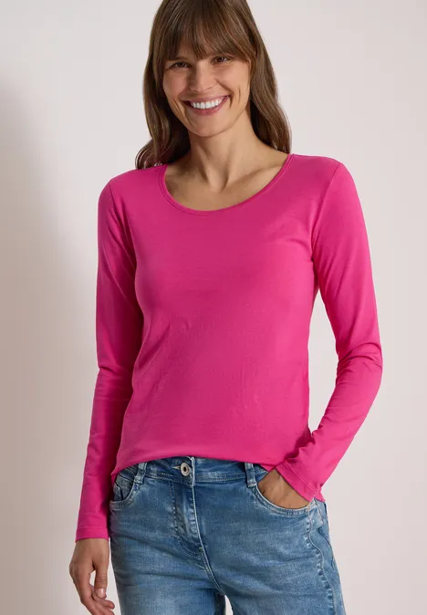 Basic Shirt mit Rundhals im 2er-Pack pink flash/truffle brown Lächelnde Frau in pinkem Langarmshirt und Jeans vor neutralem Hintergrund.