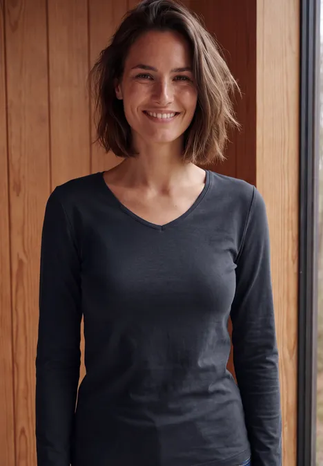 Longsleeve met V-hals urban dark blue Frau mit braunen Haaren, lächelnd, schwarzes Langarmshirt vor Holzwand.