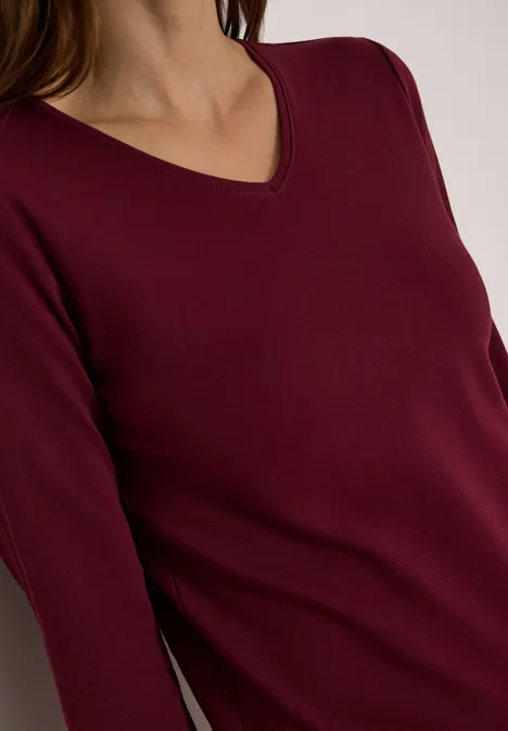 Langarm Shirt in Unifarbe mit V-Neck red wine Oberkörper einer Person in weinrotem, langärmligem V-Ausschnittoberteil.