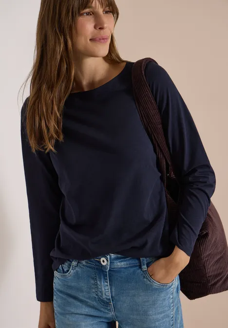Langarm Shirt mit U-Boot-Ausschnitt urban dark blue Eine Frau in lässigem Outfit mit dunkelblauem Langarmshirt, Jeans und Umhängetasche.