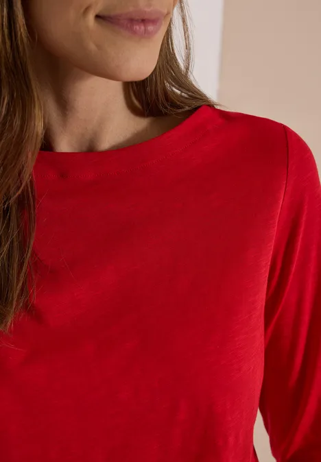 Langarm Shirt mit U-Boot-Ausschnitt flame red Teilansicht einer Frau in rotem Langarmshirt.