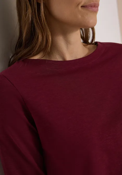 Langarm Shirt mit U-Boot-Ausschnitt red wine Teilaufnahme einer Frau mit burgunderfarbenem Langarmshirt und leicht seitlich gedrehtem Oberkörper.
