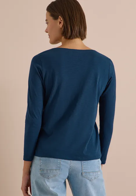 Langarm Shirt mit U-Boot-Ausschnitt moonlight blue Frau in dunkelblauem Langarmshirt und hellblauen Jeans, seitlich von hinten gezeigt.