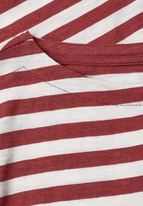 Gros plan d'un vêtement à rayures rouges et blanches avec une couture visible au col.