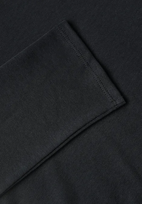 Gros plan sur un T-shirt en coton noir présentant une manche pliée.