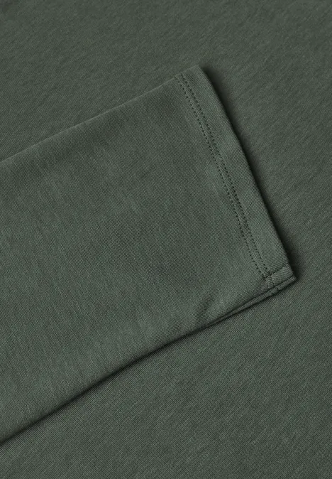 Nahaufnahme eines dunkelgrünen Ärmelendes mit sauberer Naht an einem Baumwollshirt.