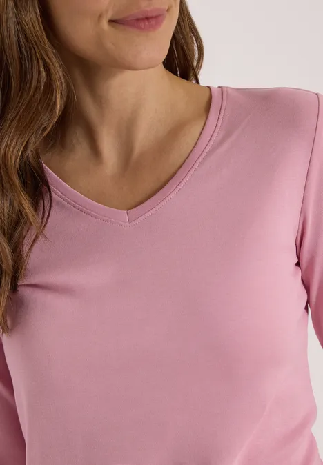 3/4-Arm Shirt in Unifarbe mit V-Neck mellow rose Frauenoberkörper in rosafarbenem Shirt mit V-Ausschnitt und langen Ärmeln, braunes Haar über der Schulter.